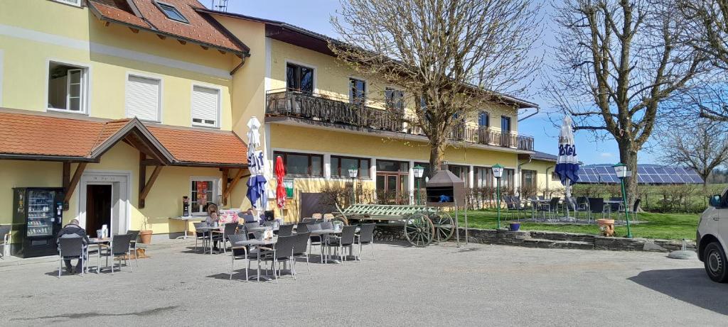 a building with tables and chairs in front of it at Wirtin z Atzersdorf 