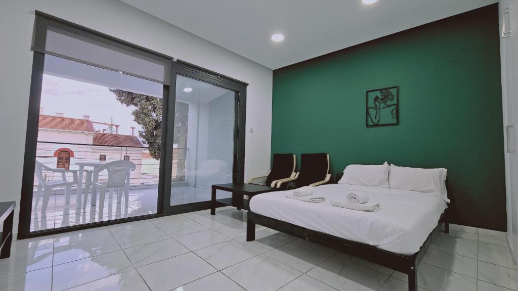 een slaapkamer met een bed en een groene muur bij STAY Cypress Studio in Limassol