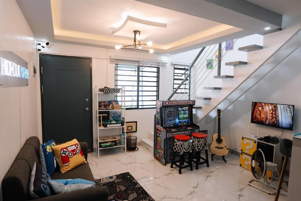 una sala de estar con una escalera y una habitación con una guitarra en Hideout Airbnb, en Pandi