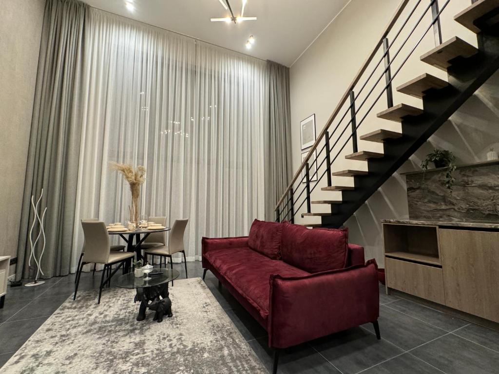 a living room with a red couch and a table at Cukura Loft in Jelgava