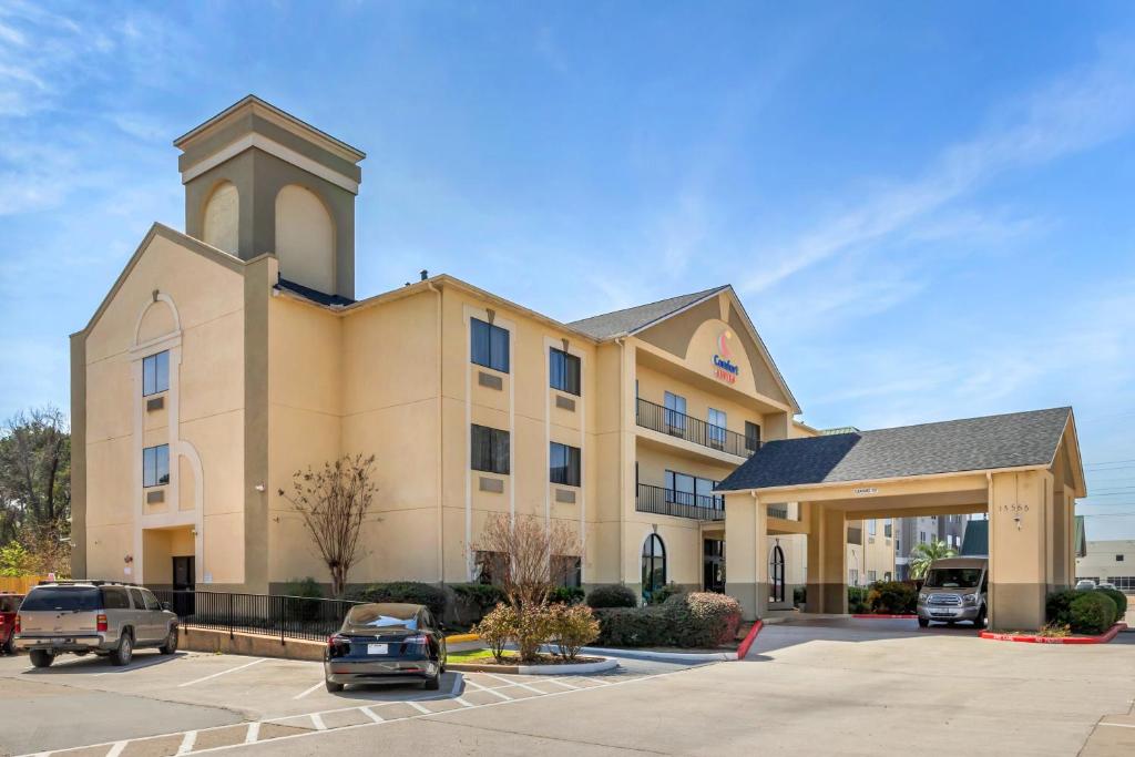 un hotel con coches estacionados en un estacionamiento en Comfort Suites Bush Intercontinental Airport en Houston