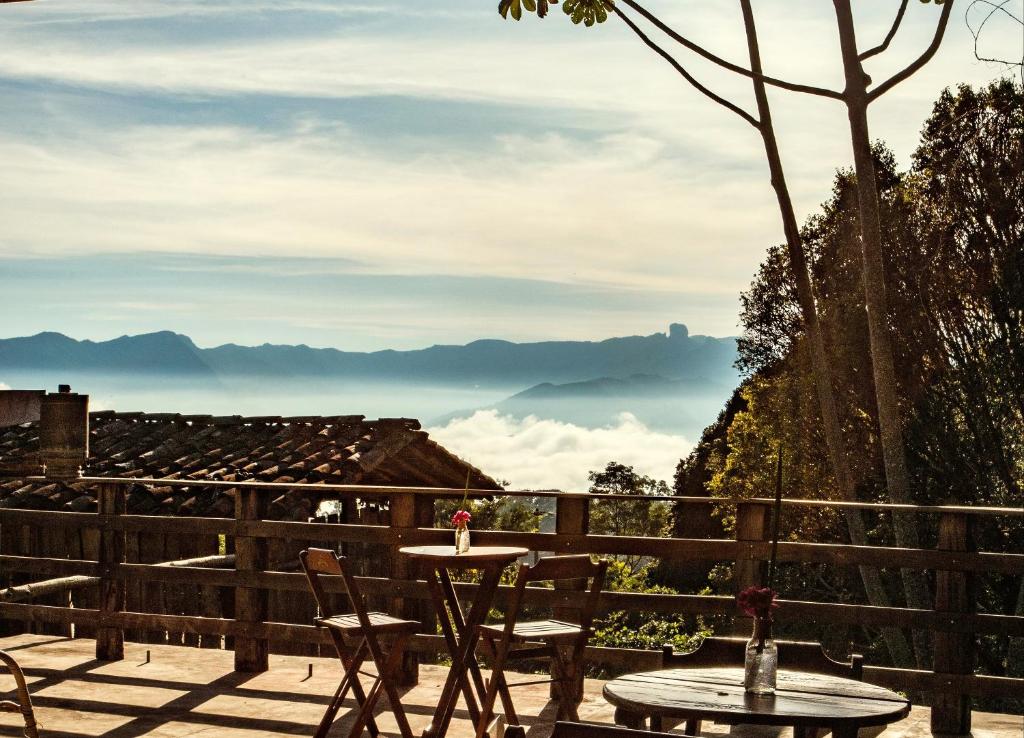 a table and chairs on a patio with a view at Hospedaria Vida na Roça in São Bento do Sapucaí