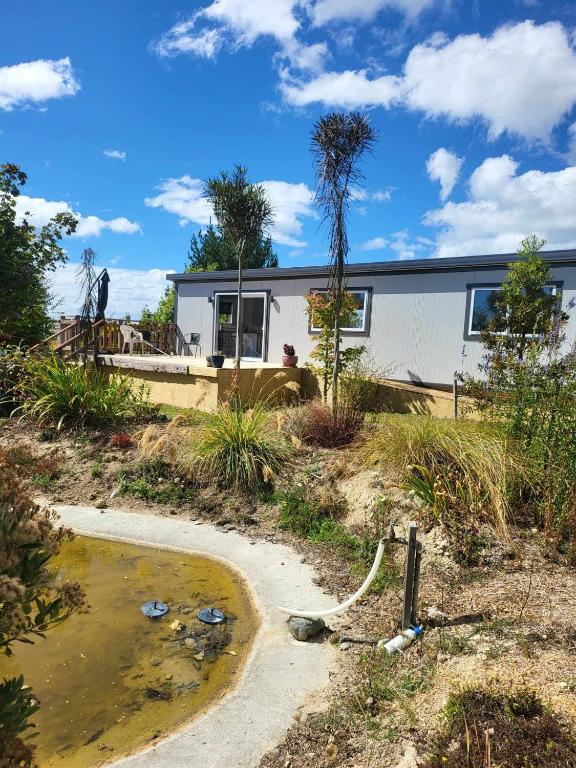 ein Haus mit einem Teich davor in der Unterkunft Hillview in Waimate