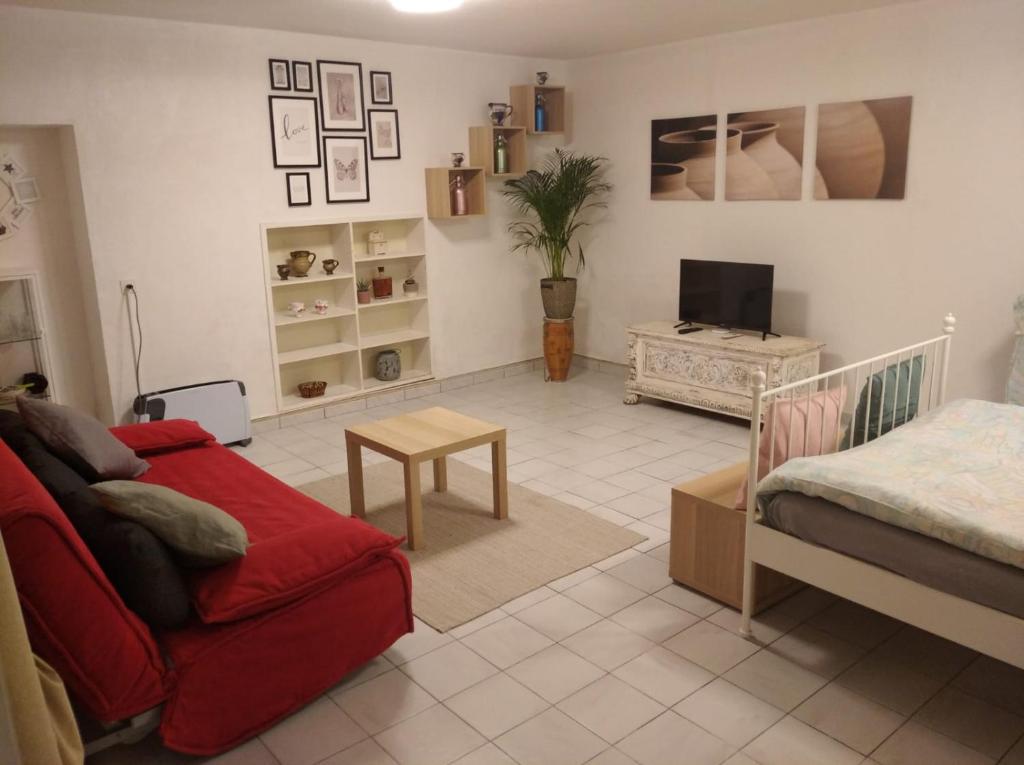 uma sala de estar com um sofá vermelho e uma televisão em Anna's Home * em Campione dʼItalia