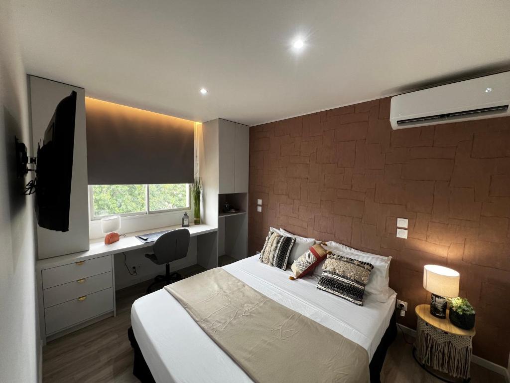 een slaapkamer met een bed en een bureau. bij Chambre Terra Cota in Cayenne