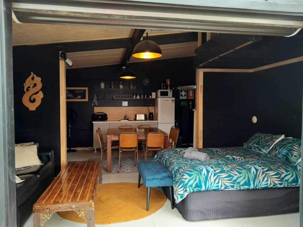 a bedroom with a bed and a table and a kitchen at Glamp Two-Five-Oh 