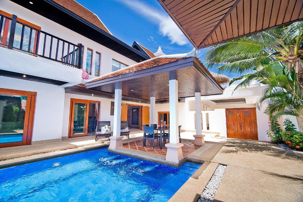 ein Haus mit einem Pool vor einem Haus in der Unterkunft Tropicana Pool Villa in Jomtien Beach
