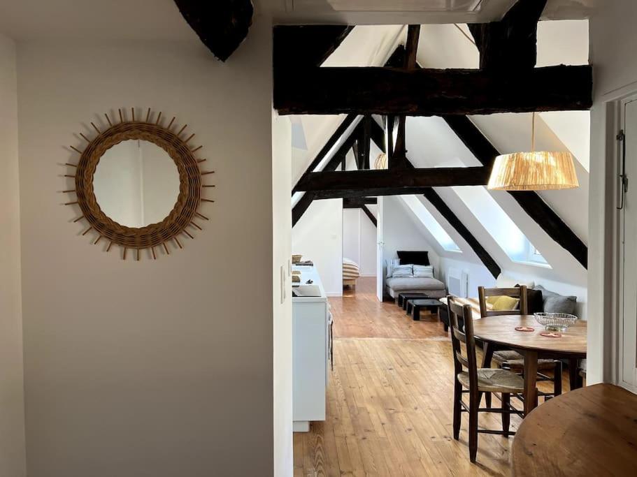 - un salon avec une table et un miroir dans l'établissement Charmant T4 entièrement rénové !, à Lannion