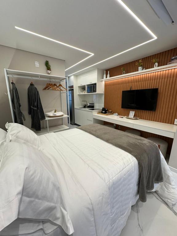 1 dormitorio con 1 cama blanca grande y TV en B/F Studio 704, en São Paulo