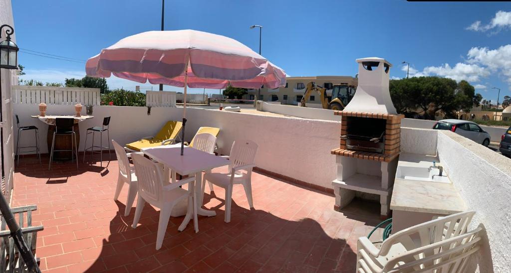 patio con tavolo, ombrellone e griglia di Anabela Apartment a Carvoeiro