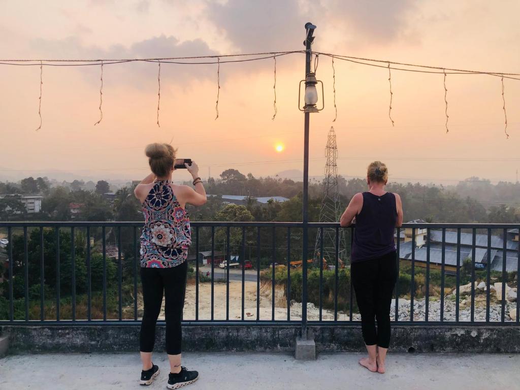 two women taking a picture of the sunset at Hayat Residency - The Quarry Lake in Kalpetta