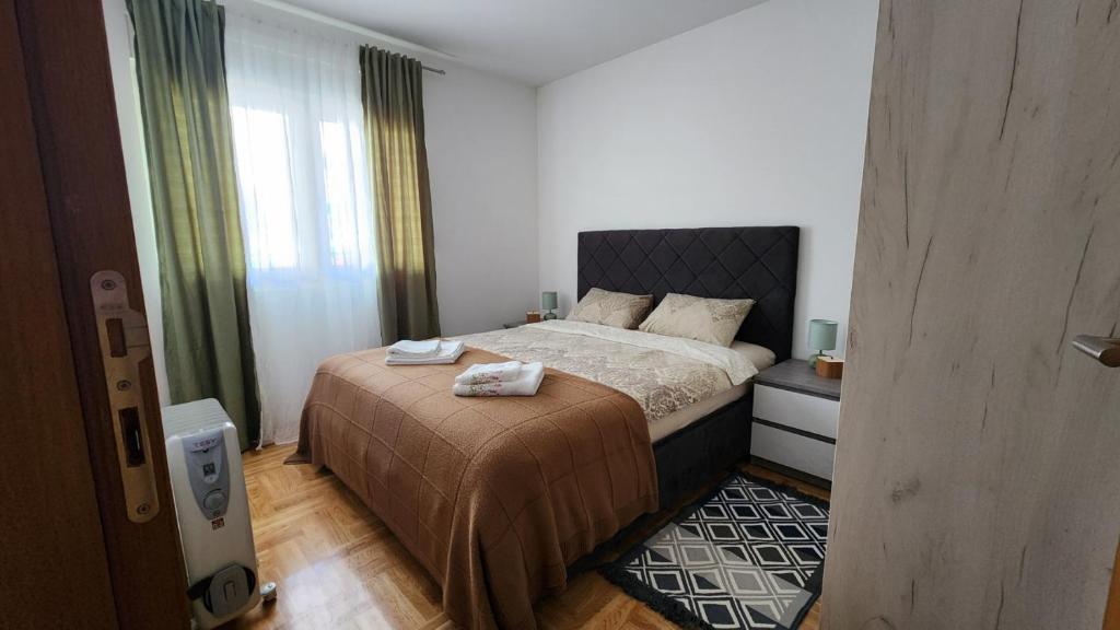Apartman TIM LUX 2 في Vrnjačka Banja: غرفة نوم عليها سرير وفوط