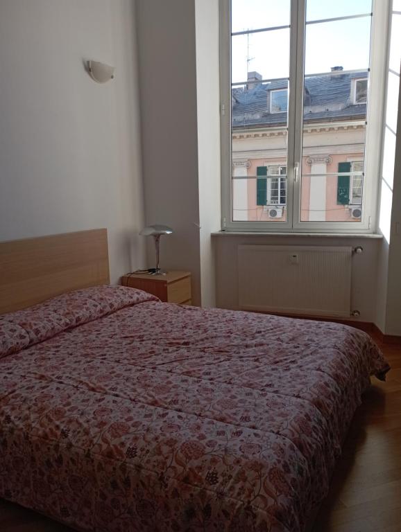 - une chambre avec un lit et une grande fenêtre dans l'établissement Raibetta Apartment, à Gênes