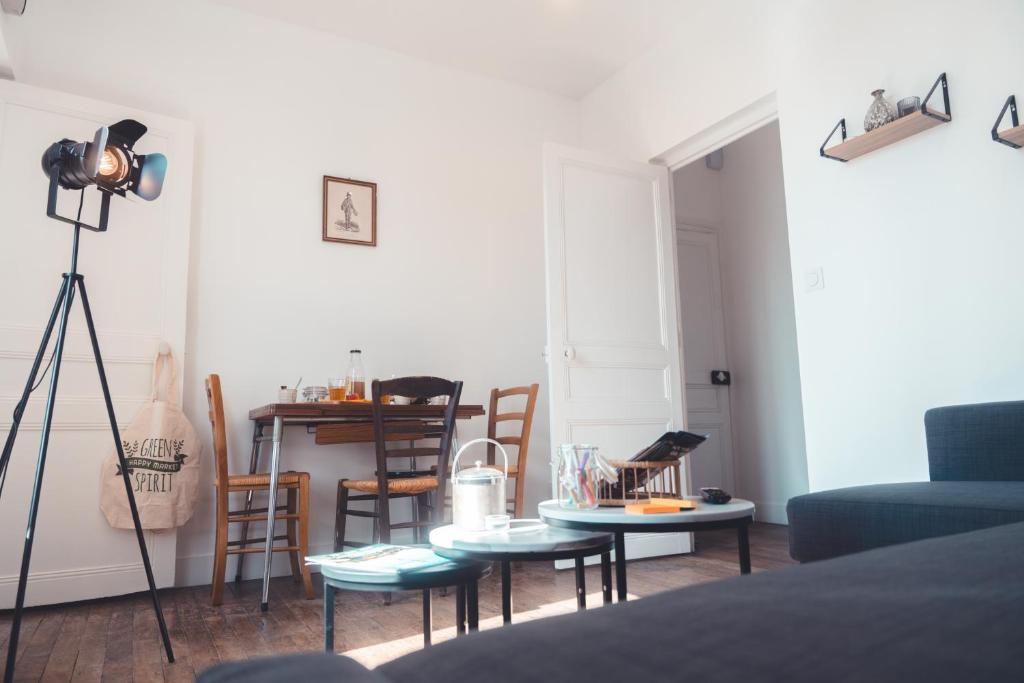 een woonkamer met een bank en een tafel en stoelen bij Le Chenin T2 pour 4 personnes in Tours