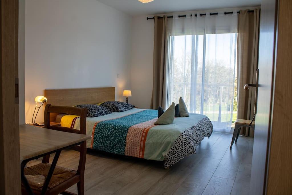 a bedroom with a bed and a large window at Ti Ar Park/ Wifi /Grands espaces in Roscanvel