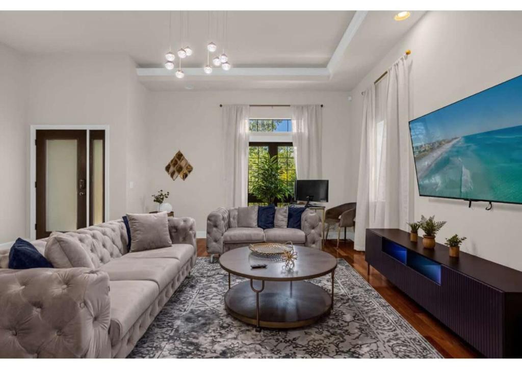 a living room with a couch and a table at Luxury Model Townhome - 5 minutes from Disney in Orlando