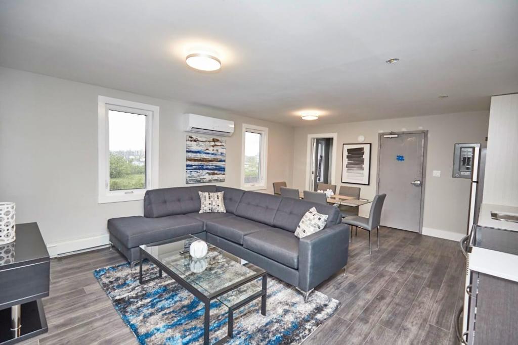 uma sala de estar com um sofá e uma mesa em Clifton Hill Hideaway 3B - Two Bedroom Condo em Cataratas do Niágara