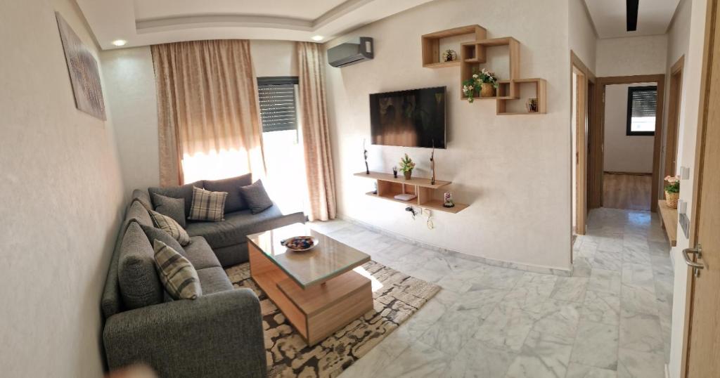 - un salon avec un canapé et une table dans l'établissement Zenata ocean park appartement, à Mohammedia