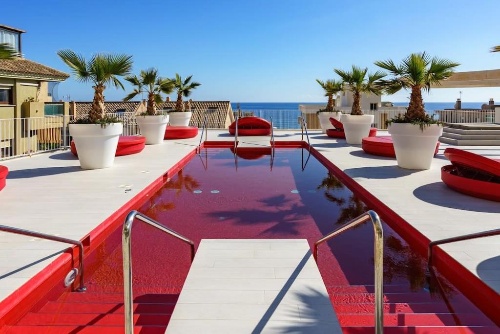 una piscina en la azotea de un edificio con palmeras en Luxury flat with sea view in Costa del Sol, en Fuengirola