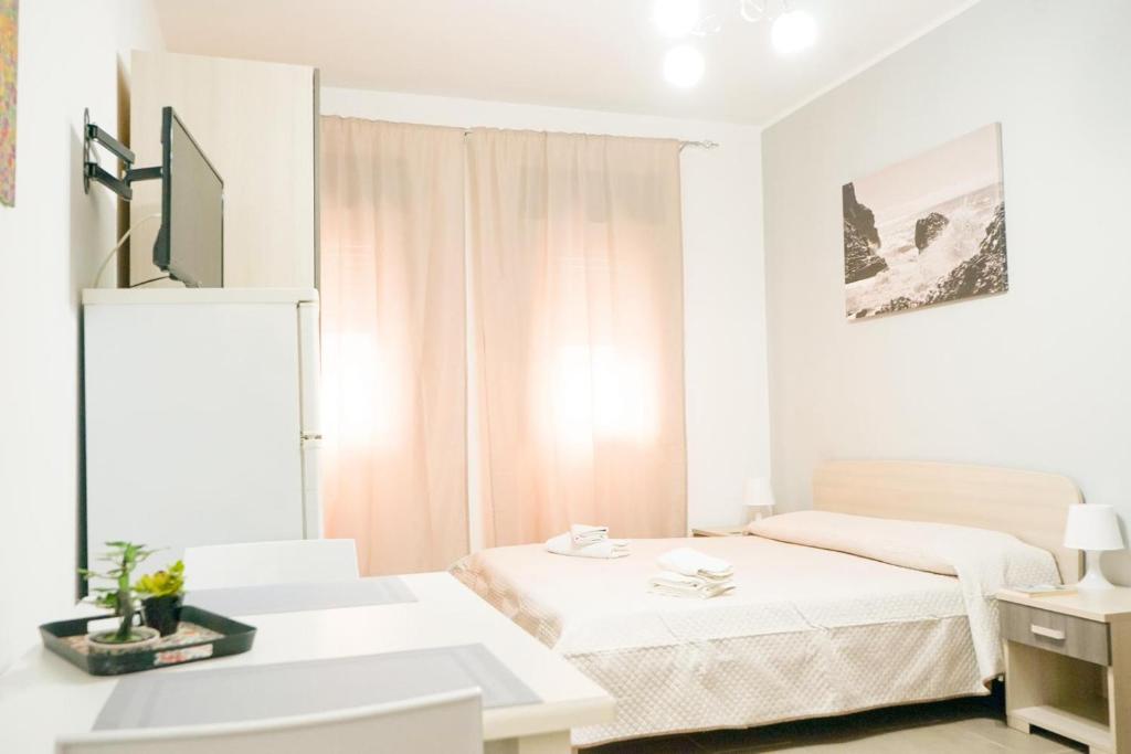 a white room with two beds and a desk at Rael in Cefalù