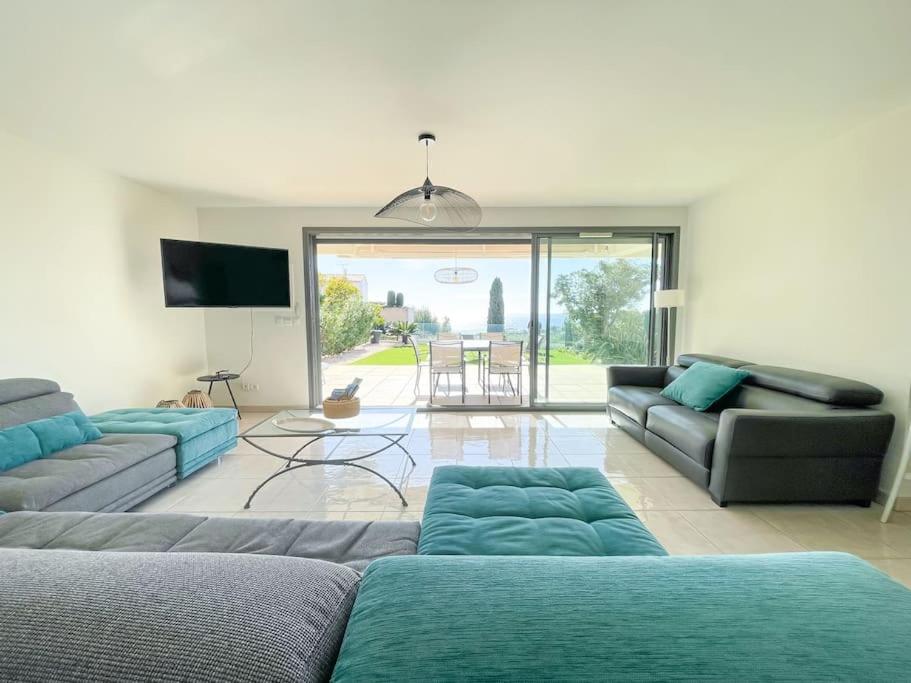 un salon avec deux canapés et une télévision dans l'établissement Le Romarin - Clim - Vue mer et Jardin - 3 Chbres, à Cassis