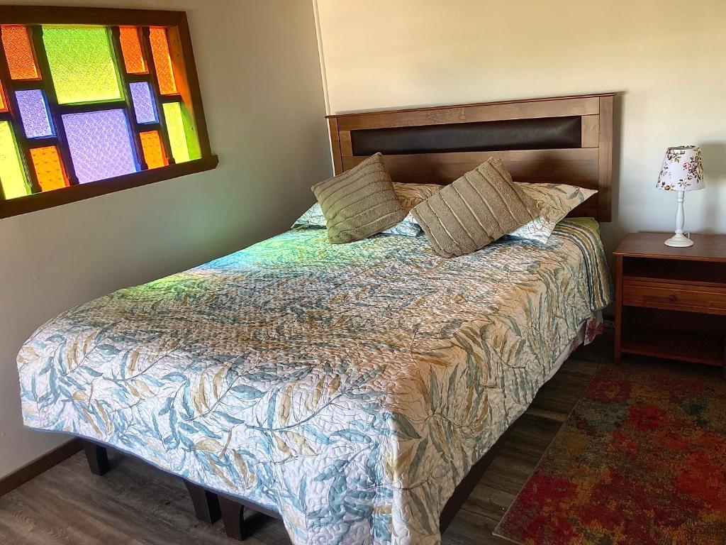 1 dormitorio con cama y vidriera en Habitación privada, vista al mar 3, en Ancud