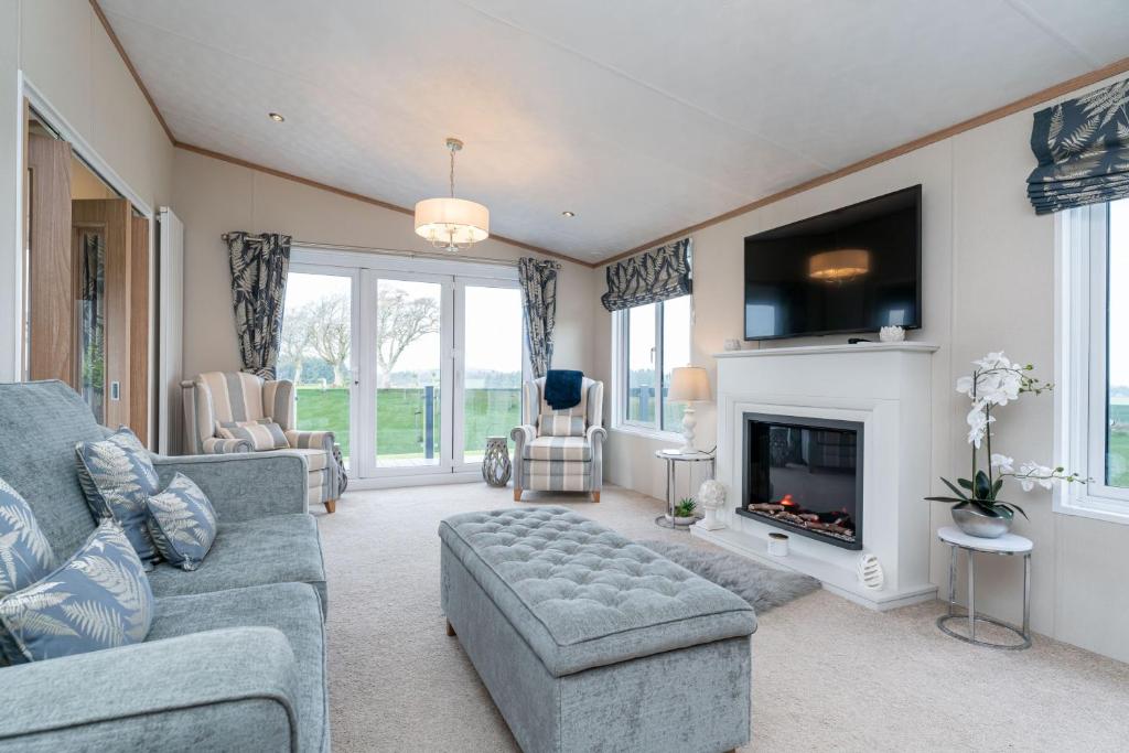 a living room with a couch and a fireplace at Stewarts Resort Lodge 18 in St Andrews