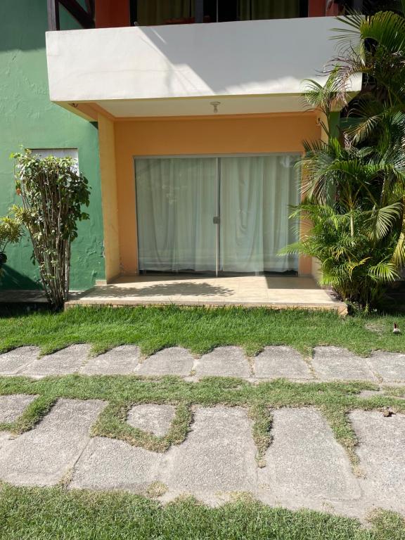 una casa con una pared verde y un patio en Apartamento próximo Arena Axé Moi, en Porto Seguro