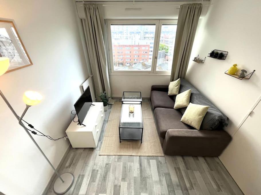 a living room with a couch and a window at Hypercentre Evry Appartement équipé avec Parking inclus in Courcouronnes