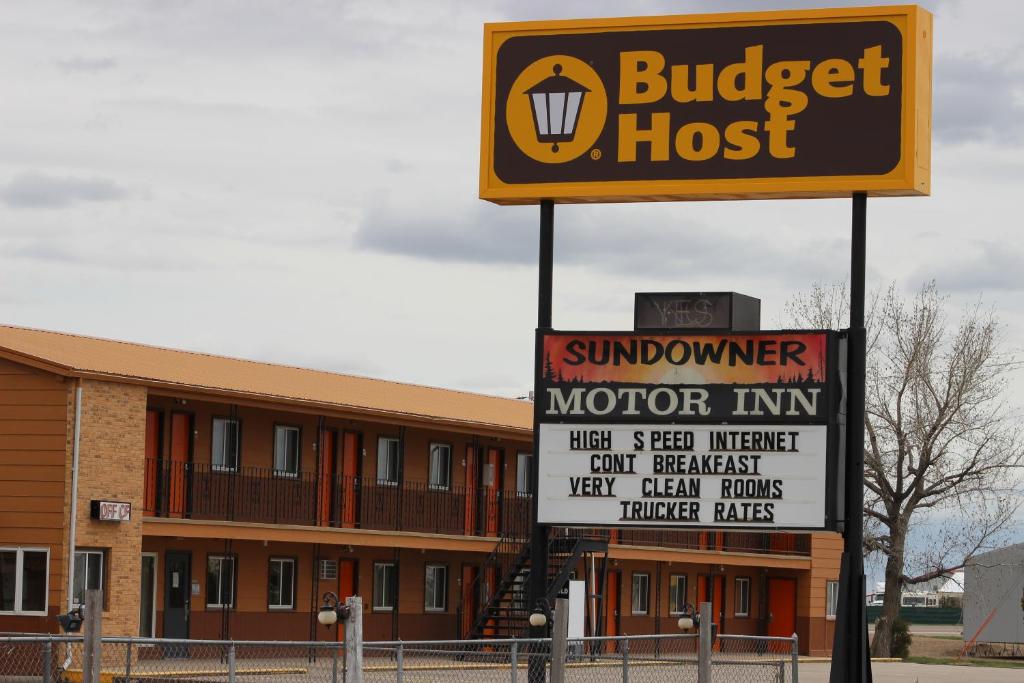 a sign in front of a building with a burger at Budget Host Sundowner Motor Inn Kadoka in Kadoka