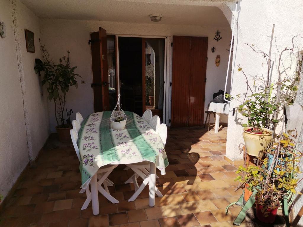 une table et des chaises dans une pièce avec des plantes dans l'établissement La Maison du Vent du Soleil - située au cœur de la Camargue, à Saintes-Maries-de-la-Mer
