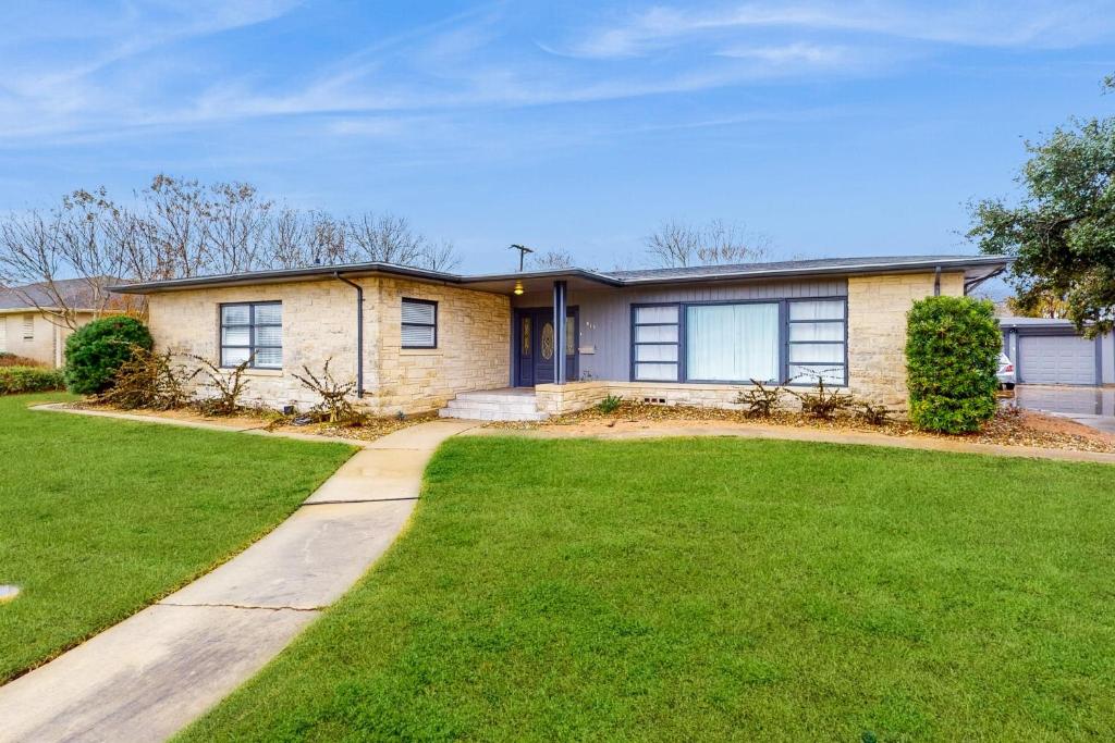 a house with a green lawn in front of it at Hello There in Corpus Christi