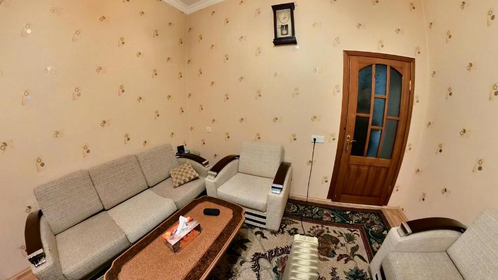 a living room with a couch and two chairs at Fountain Square Apartment in Baku