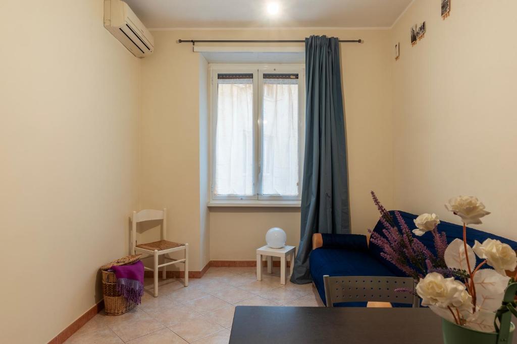 a living room with a blue couch and a window at Piazzale delle Provincie Apartment in Rome