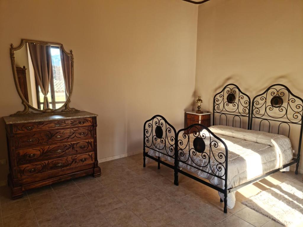 a bedroom with a bed and a dresser and a mirror at Antica Domus in Raiano