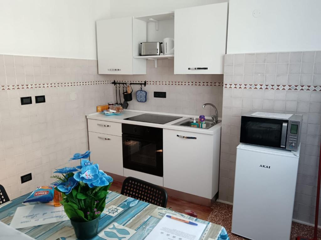 een keuken met witte kasten en een tafel met een magnetron bij Casa di Laura 2 in Genua