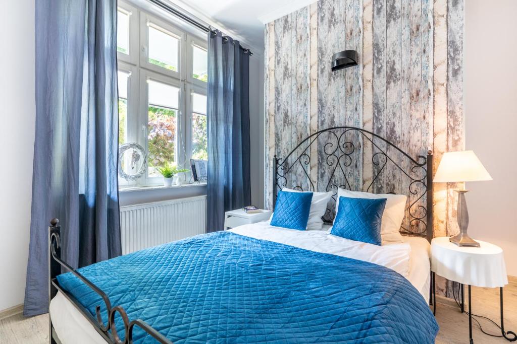 ソポトにあるBy The Sea Sopot Apartamentのベッドルーム1室(青いベッド1台、青い枕付)