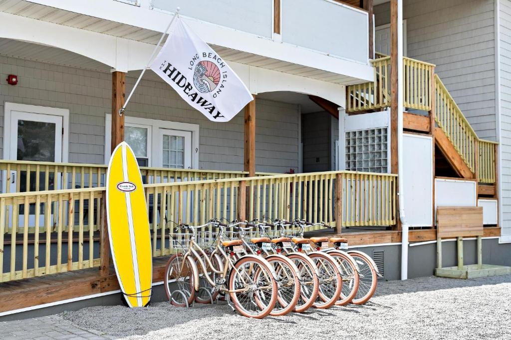 eine Gruppe von Fahrrädern, die außerhalb eines Hauses mit einem Surfbrett geparkt werden in der Unterkunft The Hideaway Hotel in Long Beach