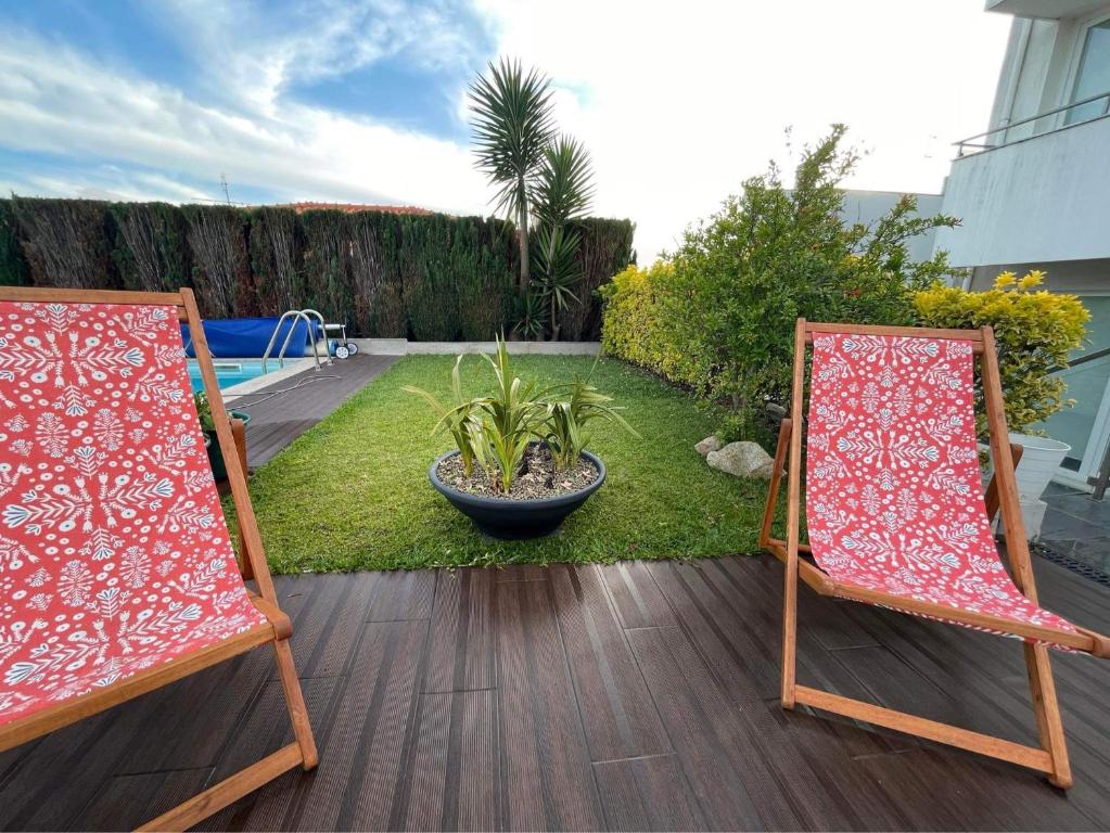2 chaises assises sur une terrasse dans un jardin dans l'établissement Casa Beiriz, à Póvoa de Varzim