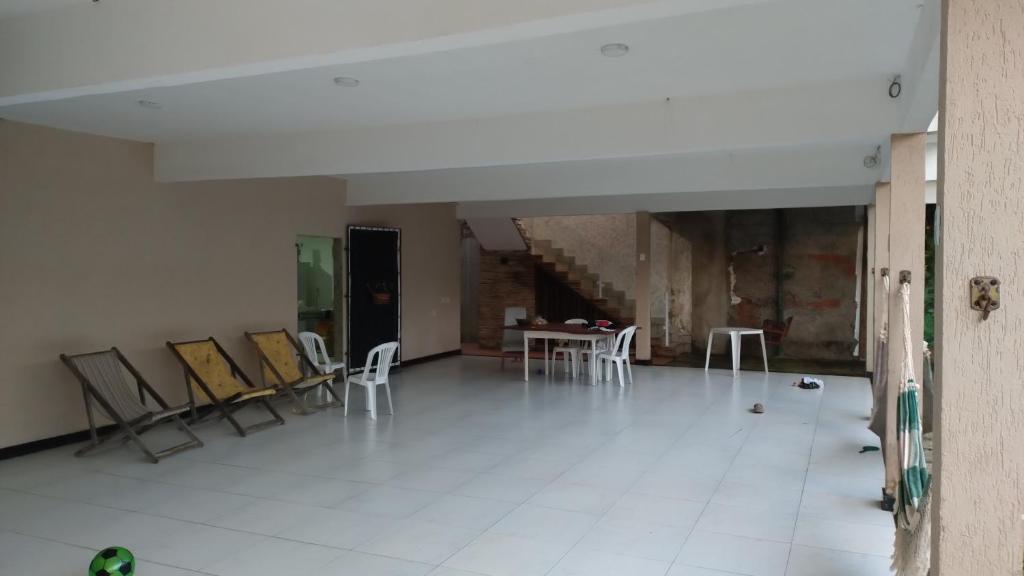 an empty room with chairs and a table in it at Casa de Praia in Fundão