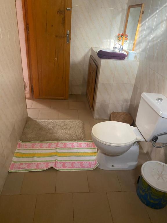 a bathroom with a toilet and a rug on the floor at Hôtel évasion pêche djilor île sine saloum in Fatick