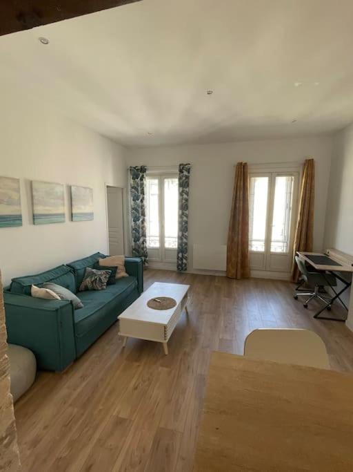 un salon avec un canapé bleu et une table dans l'établissement Charmant 2 pièces à Joliette, à Marseille