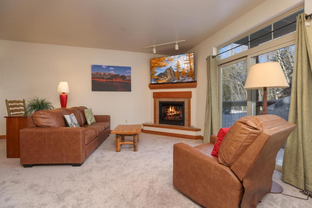 a living room with two couches and a fireplace at Retreat on the Blue Condo: Your Riverfront Retreat in Silverthorne
