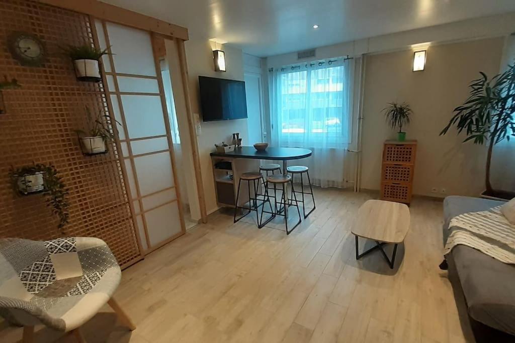 sala de estar con mesa y sillas en Joli Appartement T2 avec Balcon "Le nid Libaud" en Chalon-sur-Saône