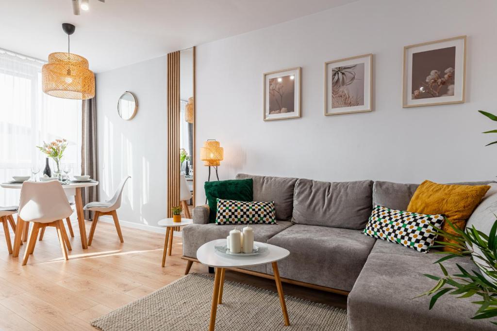 a living room with a gray couch and a table at 9th Floor Wroclaw Business Apartment by Rentujemy in Wrocław