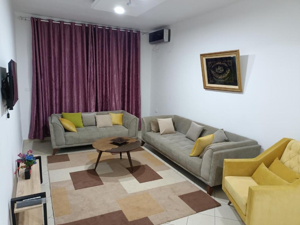 a living room with two couches and a table at IMMEUBLE BRINI in Kairouan