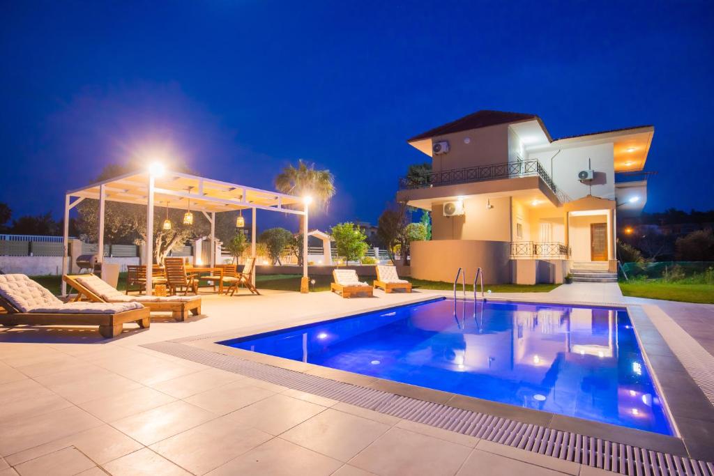 a villa with a swimming pool at night at Villa Cervus Dianae in Kallithea Rhodes