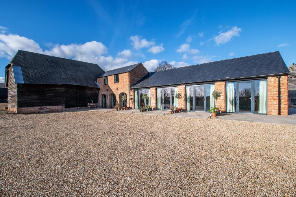 a house with a black roof and a gravel yard at The Linhay in Peterborough