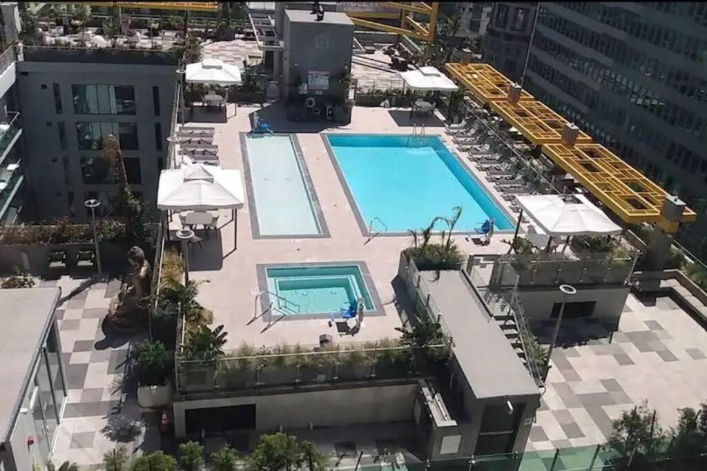 Comfy Cozy Apt with pool & hot tub in downtown LA' في لوس أنجلوس: اطلالة علوية على مسبح فوق مبنى