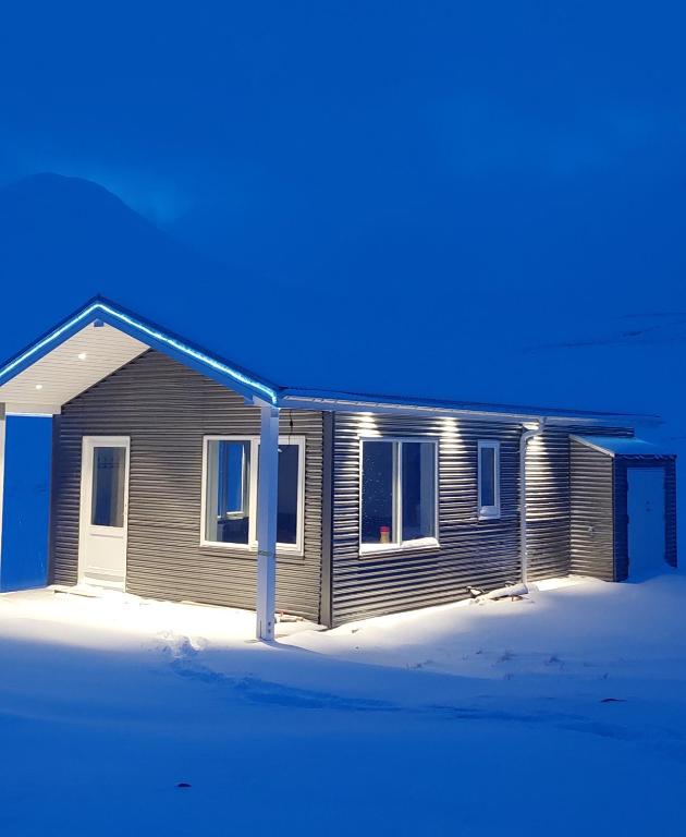 Una casa en la nieve con un azul en Tungukot sumarhús, en Akureyri